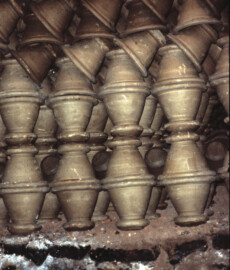 Many pots stacked on each other rim to rim and foot to foot (mostly)